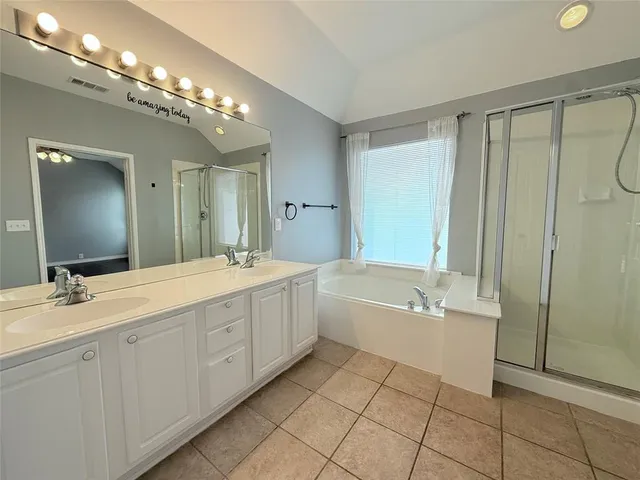 a spacious bathroom with a double vanity sink a mirror and a bathtub