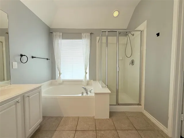 a bathroom with a tub a sink a mirror and a shower