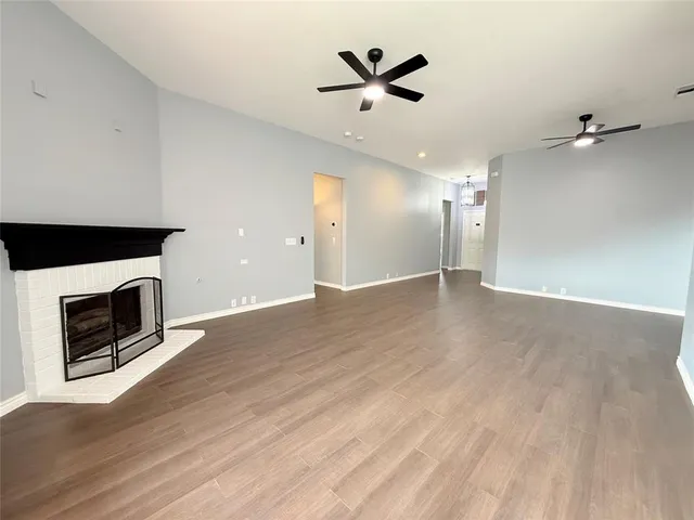 an empty room with wooden floor and a fireplace