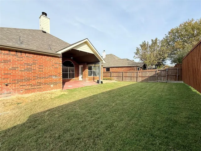 a view of a house with a backyard and a patio