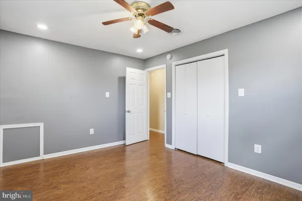 an empty room with closet and a chandelier fan