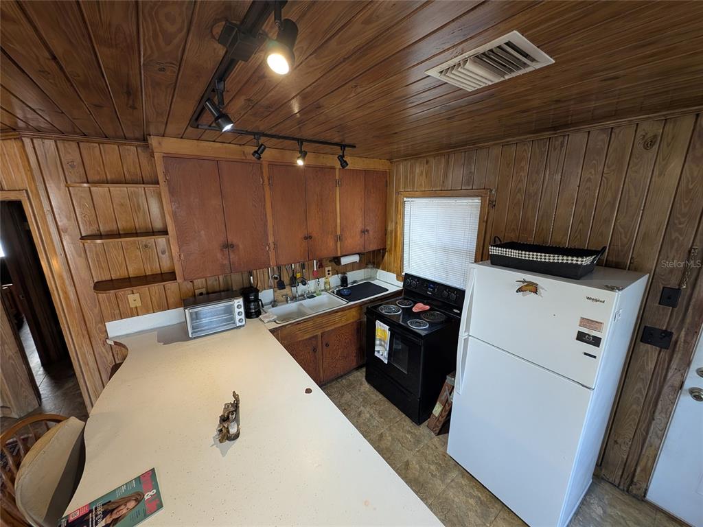 13668 Northeast 226th Avenue Road Salt Springs, FL 32134 - Photo 14 of 30 a kitchen with a stove a refrigerator and a sink