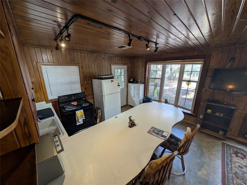 13668 Northeast 226th Avenue Road Salt Springs, FL 32134 - Photo 15 of 30 a kitchen that has a stove a table and chairs in it