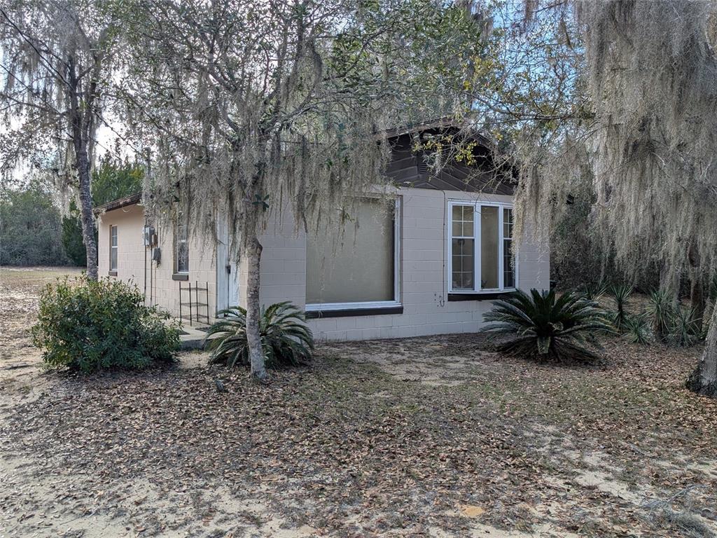 13668 Northeast 226th Avenue Road Salt Springs, FL 32134 - Photo 5 of 30 a backyard of a house with a garden and outdoor seating
