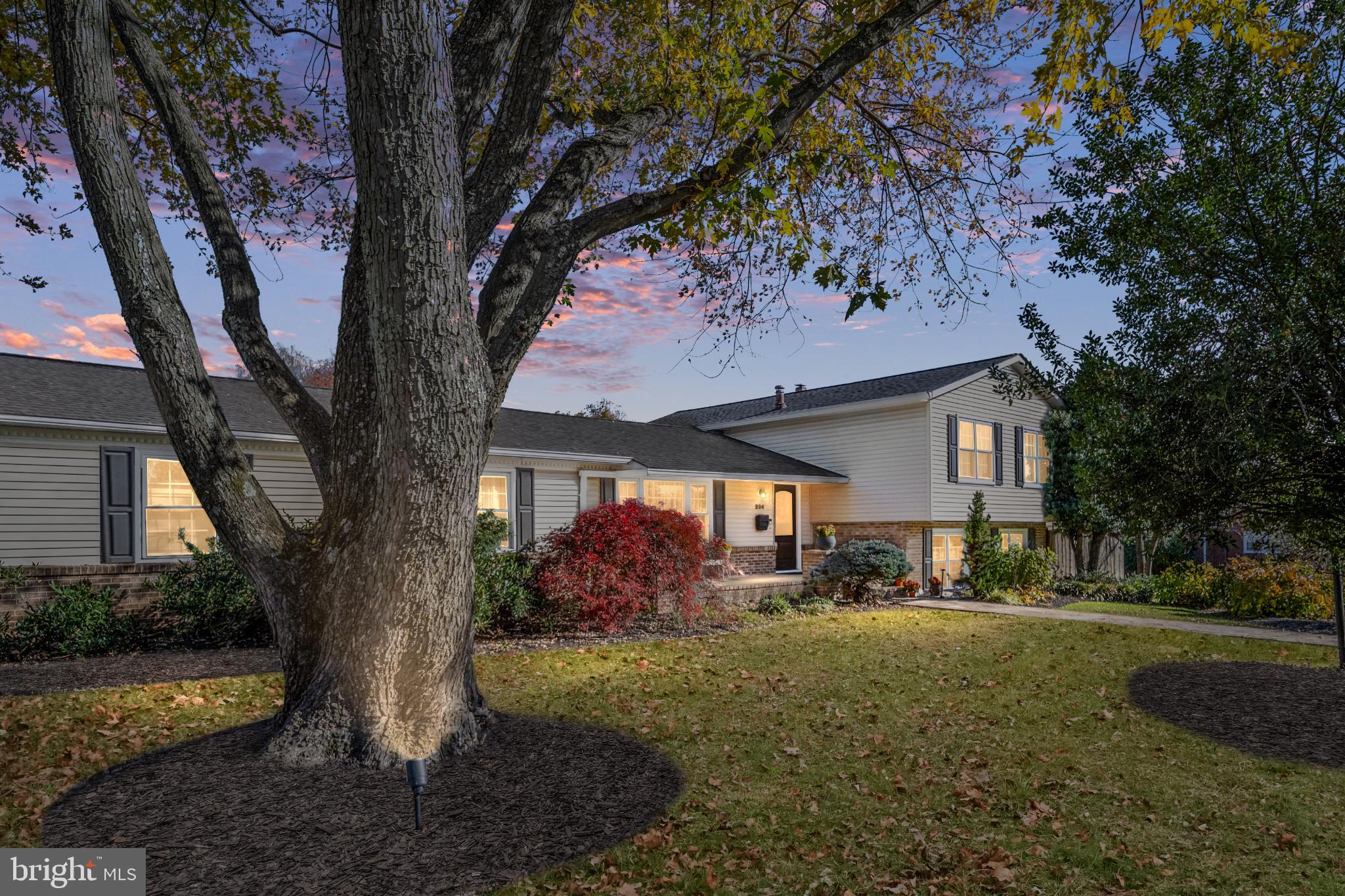 a front view of a house with a yard and mountain view