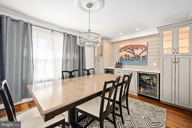 a dining hall with stainless steel appliances granite countertop a table chairs and a sink