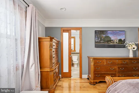 a living room with furniture a flat screen tv and kitchen view