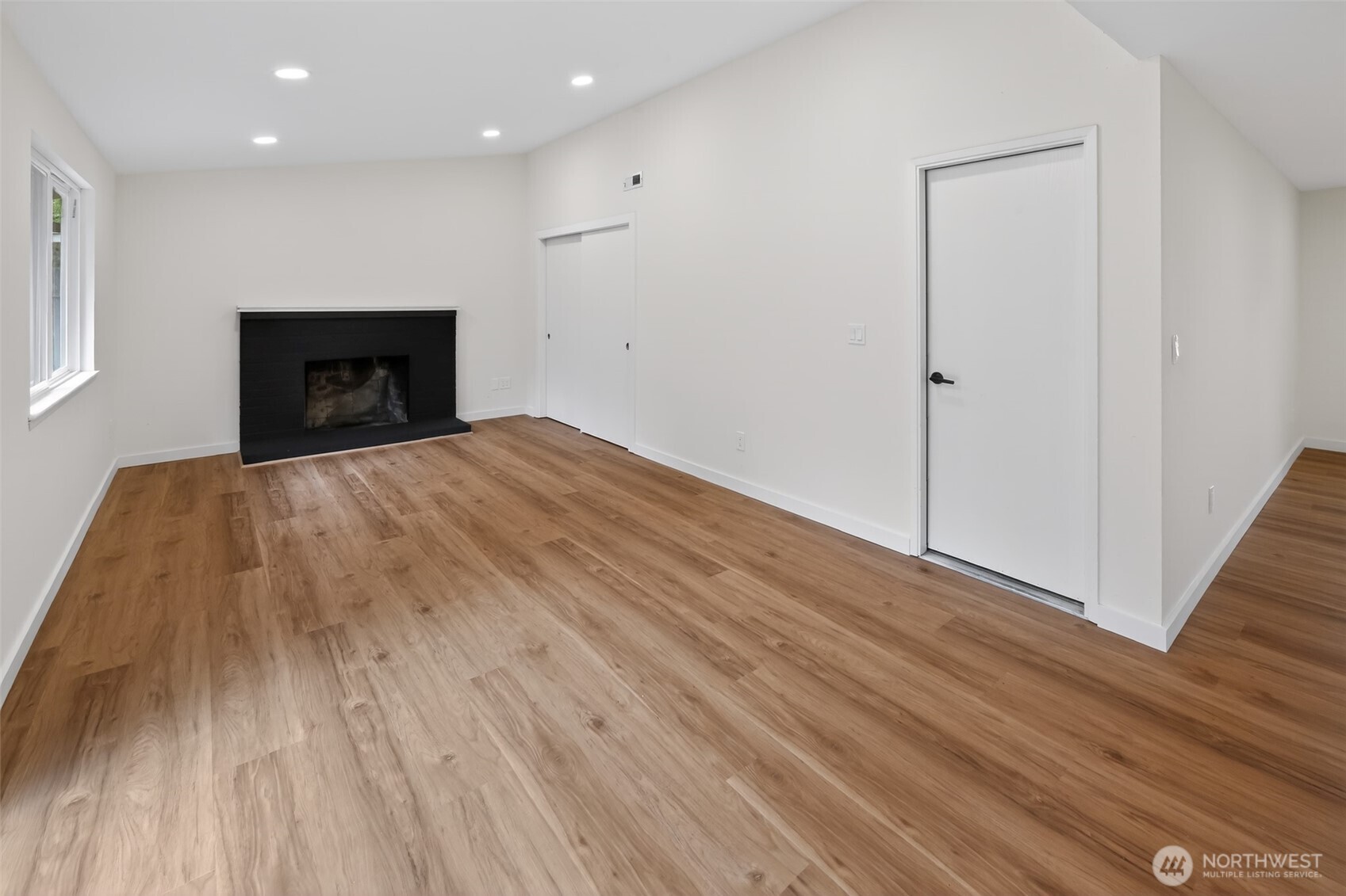 320 213th Place Southwest Bothell, WA 98021 - Photo 17 of 29 a view of empty room with wooden floor and fireplace