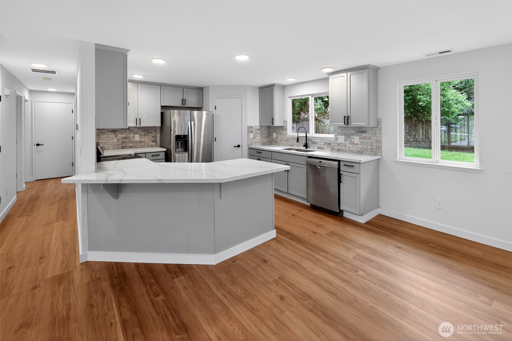 320 213th Place Southwest Bothell, WA 98021 - Photo 6 of 29 a large kitchen with stainless steel appliances granite countertop a large counter top a wooden floors and a large window