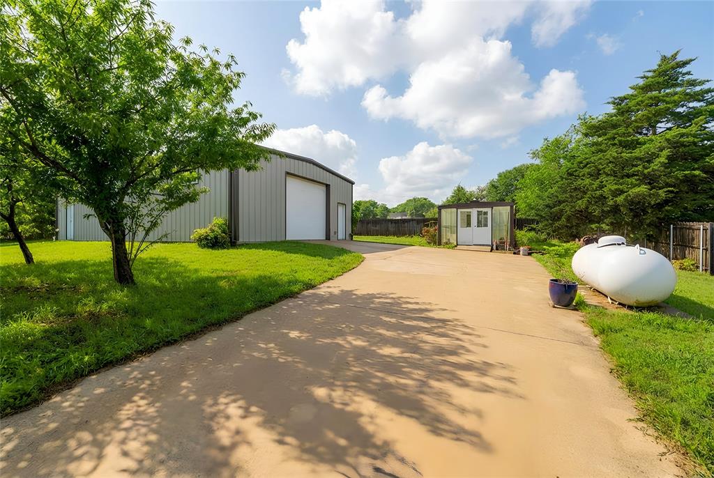 405 Kimbrough Road Azle, TX 76020 - Photo 29 of 39 a view of a backyard with a garden and trees