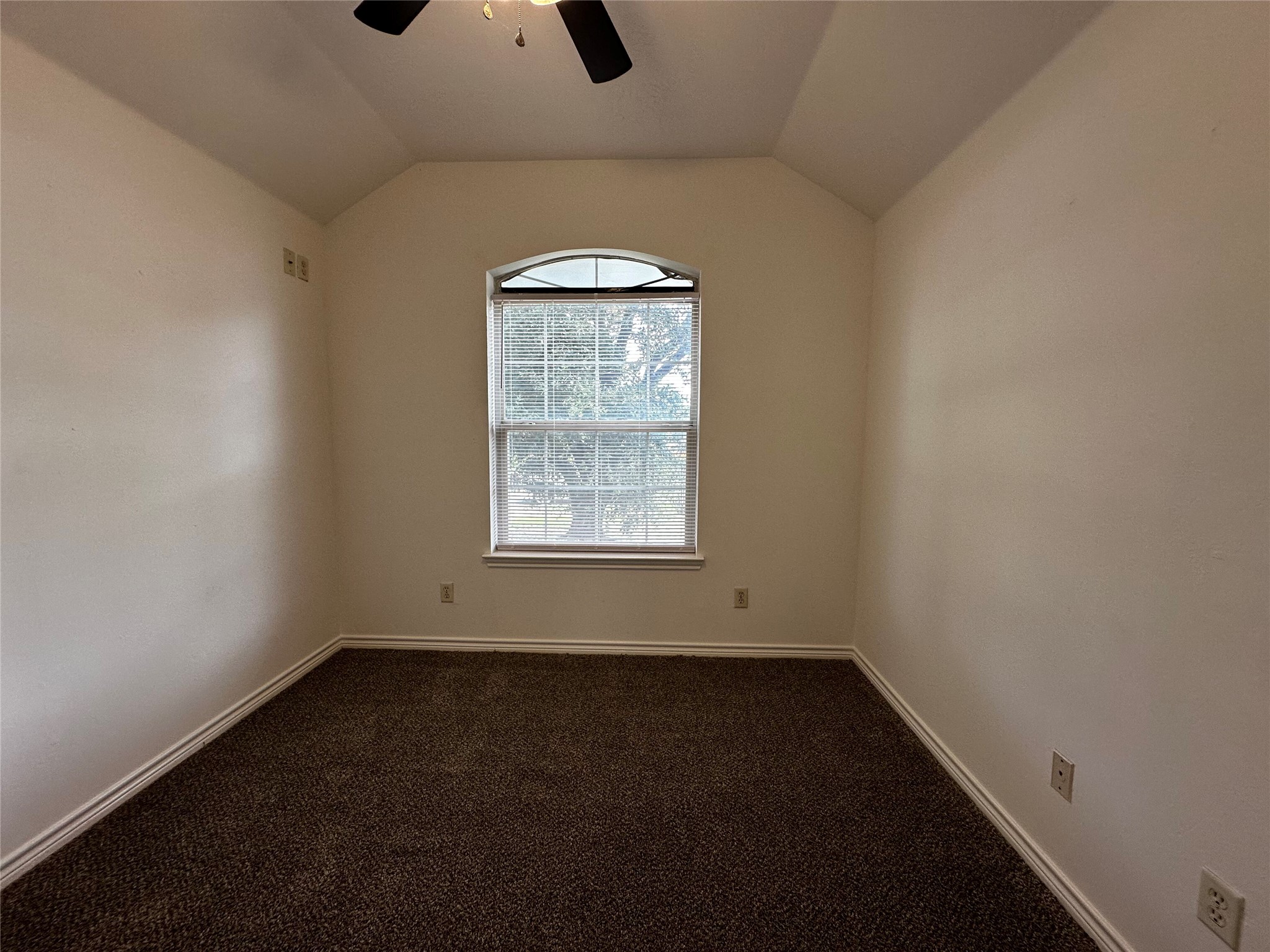 1400 Prairie Drive Bryan, TX 77802 - Photo 11 of 18 A cozy bedroom features sloped ceilings and ample natural light from an arched window.