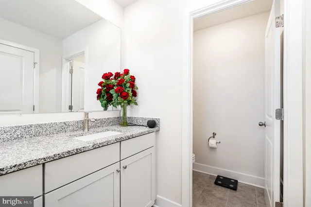 a bathroom with a granite countertop sink and a mirror