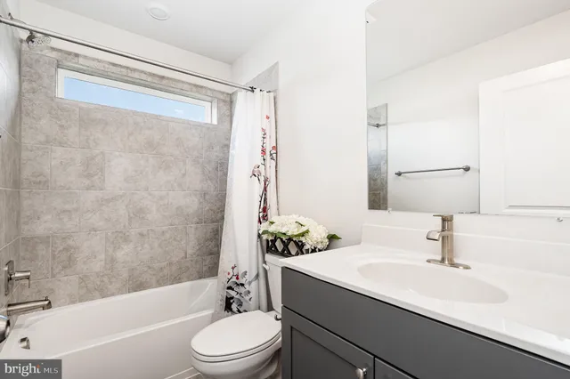 a bathroom with a sink a toilet a mirror a bathtub and shower