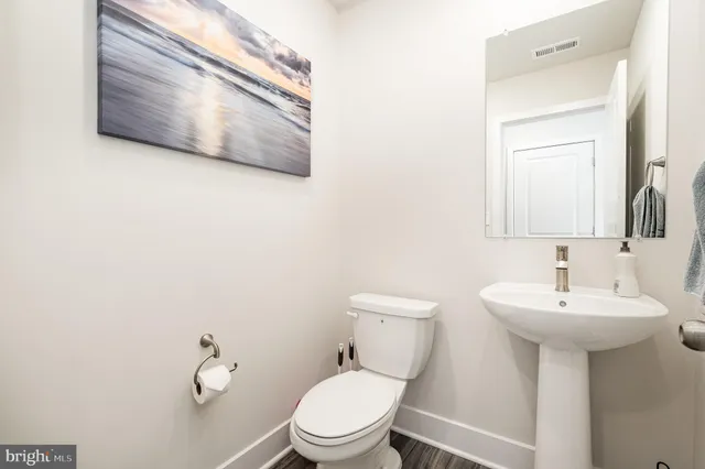 a bathroom with a toilet sink and mirror