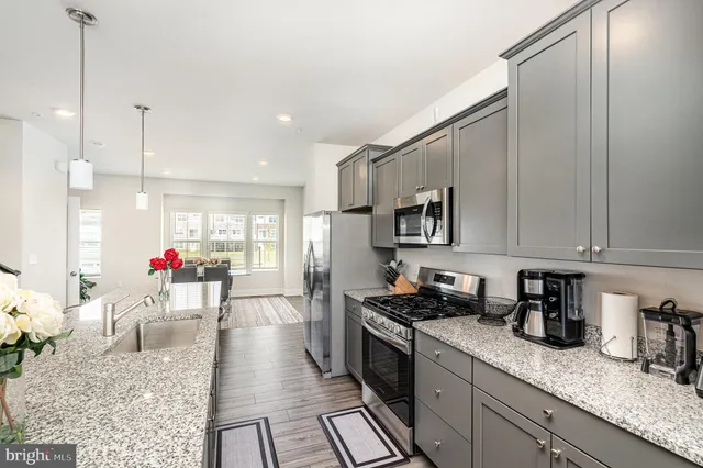 a kitchen with stainless steel appliances granite countertop a stove sink and cabinets