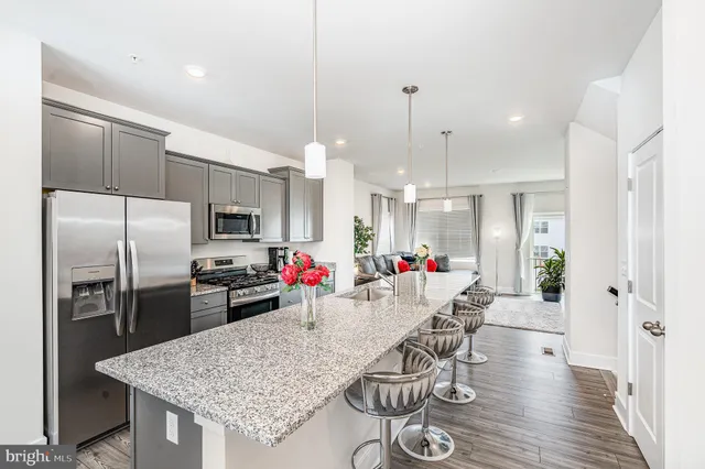 a kitchen with stainless steel appliances granite countertop a kitchen island a stove and a refrigerator