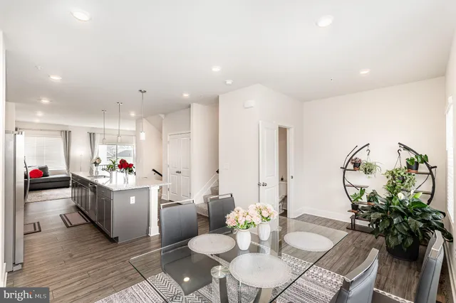 a living room with furniture and a dining table with wooden floor