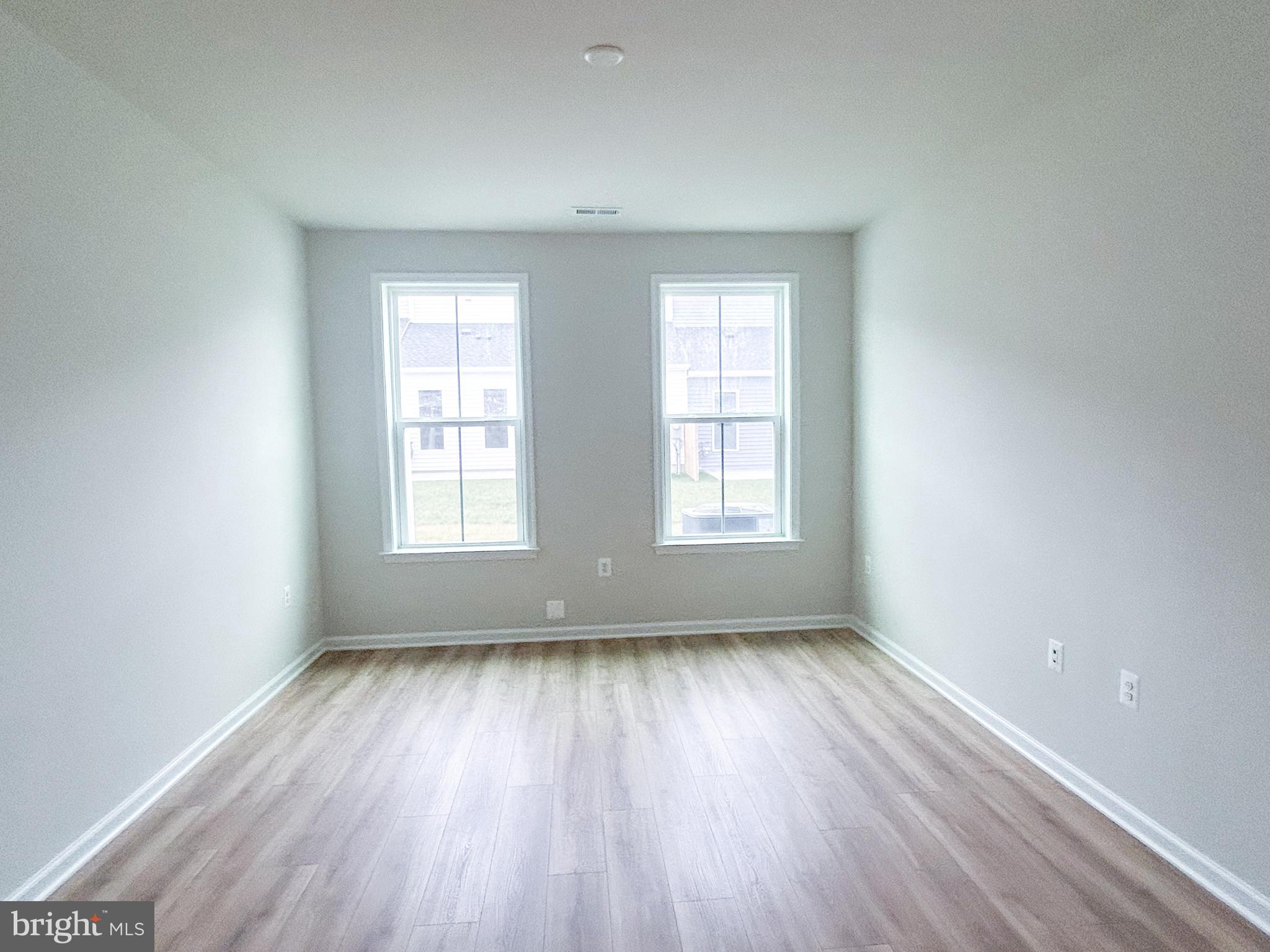 119 Heirloom Way Winchester, VA 22603 - Photo 11 of 26 an empty room with wooden floor and windows