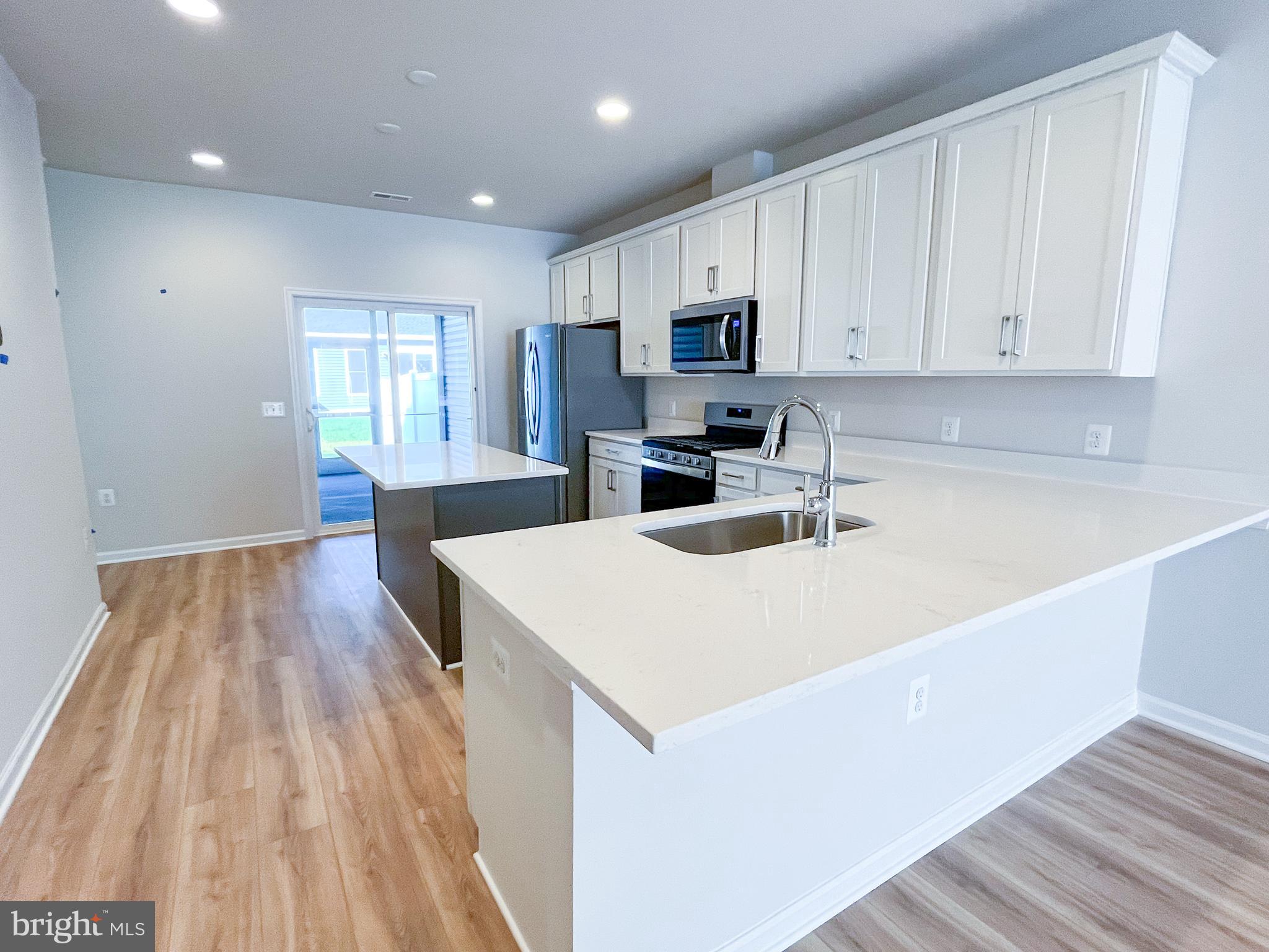 119 Heirloom Way Winchester, VA 22603 - Photo 8 of 26 a kitchen with a sink a microwave and wooden floor