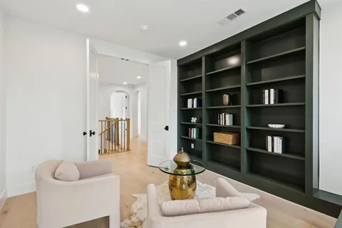 a living room with furniture and a book shelf