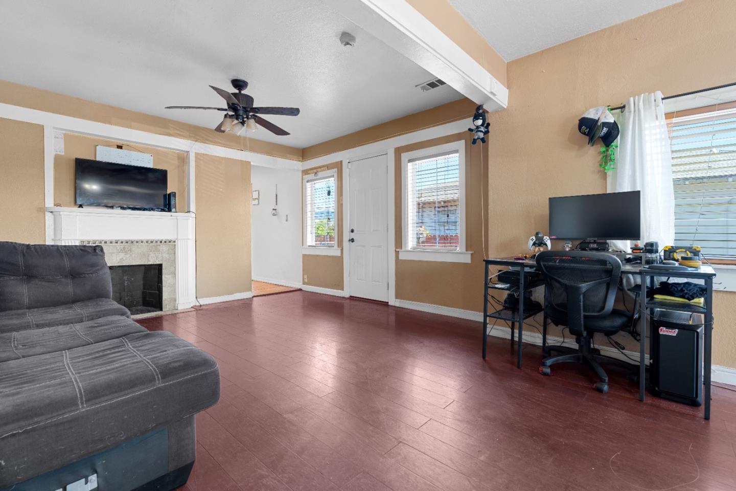 2009 69th Avenue Oakland, CA 94621 - Photo 5 of 16 a living room with furniture a fireplace and a flat screen tv