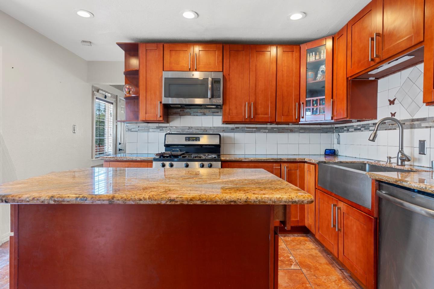 2009 69th Avenue Oakland, CA 94621 - Photo 8 of 16 a kitchen with stainless steel appliances granite countertop a sink a stove counter space and a window