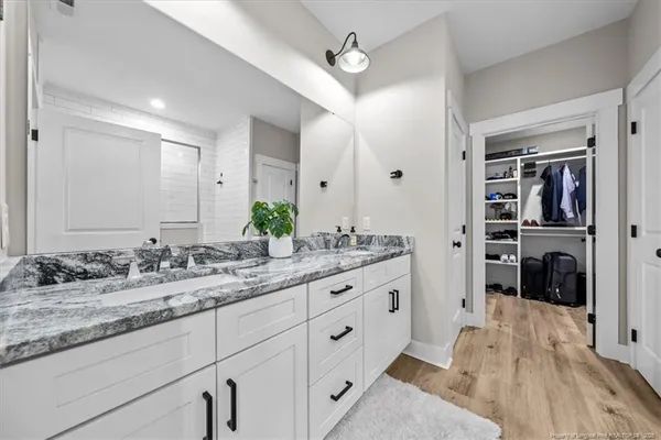 a spacious bathroom with a granite countertop sink a mirror and shower