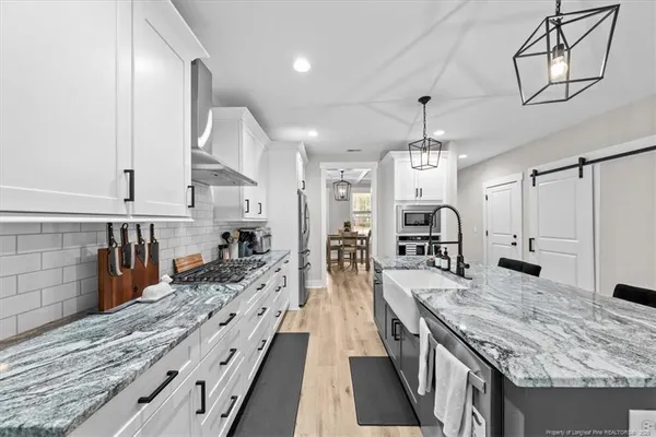 a large kitchen with kitchen island a large counter space a sink appliances and cabinets