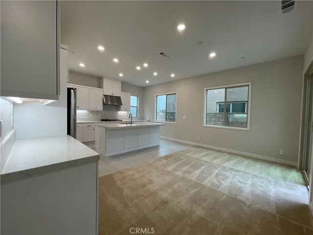 a kitchen with stainless steel appliances kitchen island granite countertop a refrigerator sink and stove