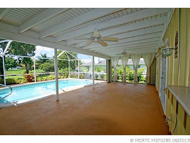 1144 Northwest Spruce Ridge Drive Stuart, FL 34994 - Photo 21 of 25 Exterior Front. Over sized covered porch with pass thru from the kitchen.