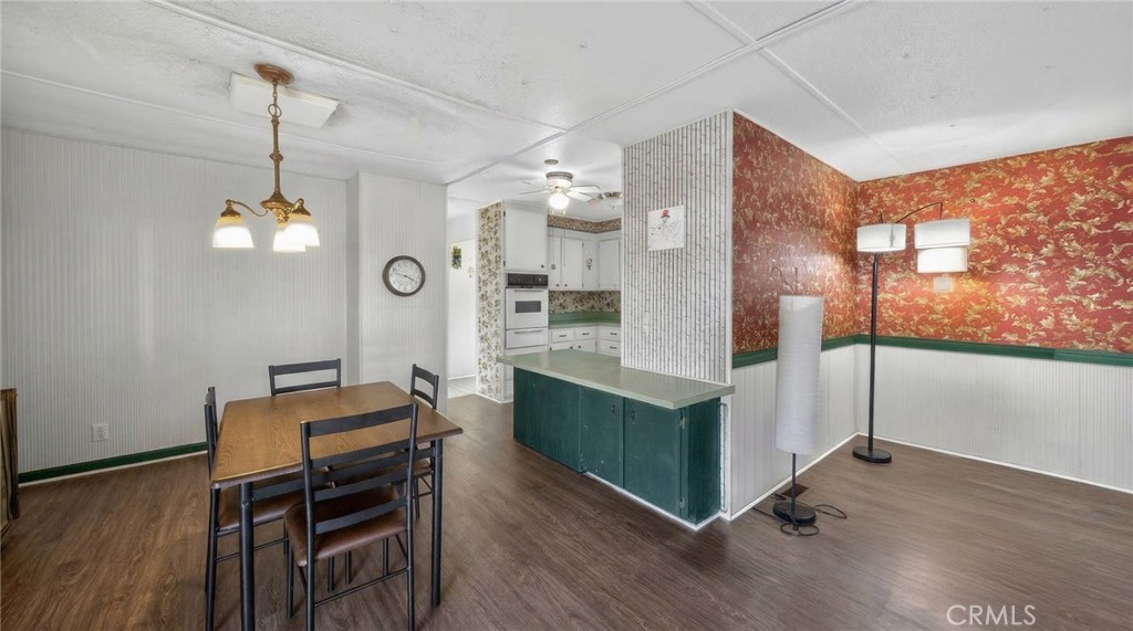 12656 2nd Street, Unit 55 Yucaipa, CA 92399 - Photo 12 of 29 a open kitchen with stainless steel appliances granite countertop a stove a refrigerator a oven and a dining table with wooden floor