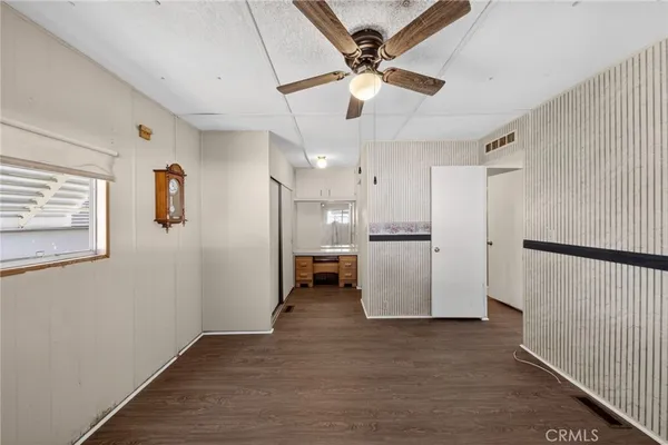 a view of a kitchen with a refrigerator a sink a kitchen wooden floor and a window