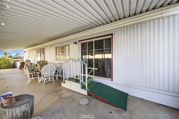 a view of a porch with chairs and floor to ceiling window