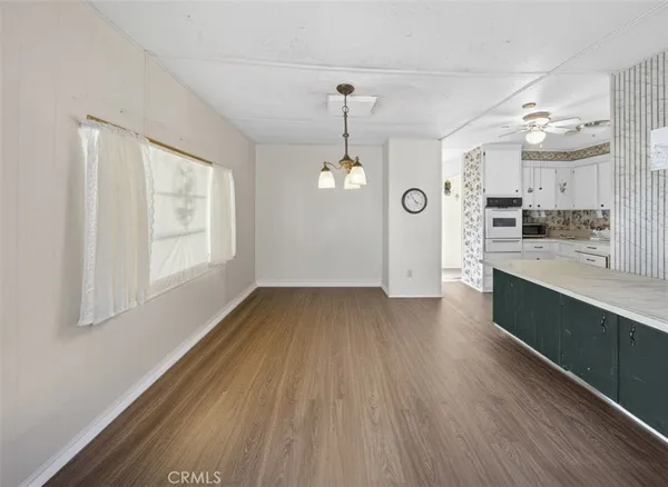 a view of large kitchen with granite countertop cabinets and wooden floor
