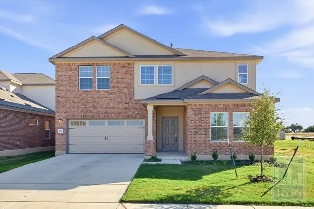 a front view of a house with a yard and garage