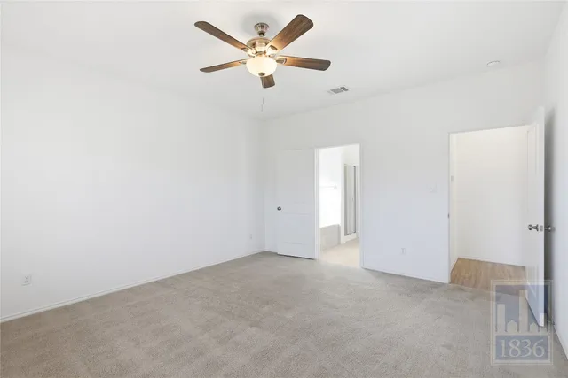 an empty room with a ceiling fan and a window