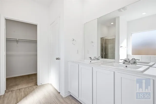 a bathroom with a double vanity sink and mirror