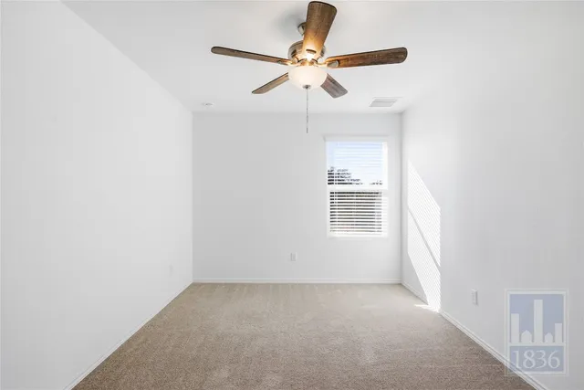 an empty room with a window and a fan