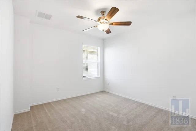 an empty room with a window and a fan