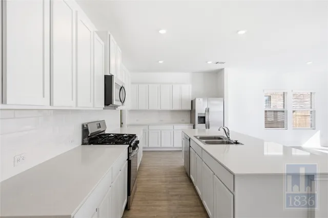 a kitchen with stainless steel appliances a sink stove and cabinets