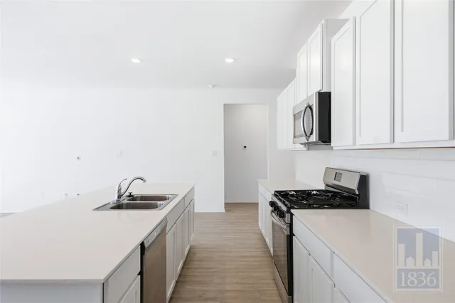 a kitchen with stainless steel appliances a sink stove and cabinets