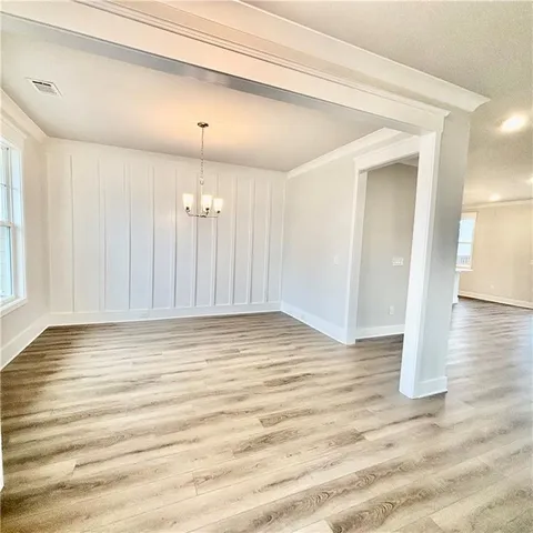 a view of a kitchen with kitchen island white cabinets and wooden floor