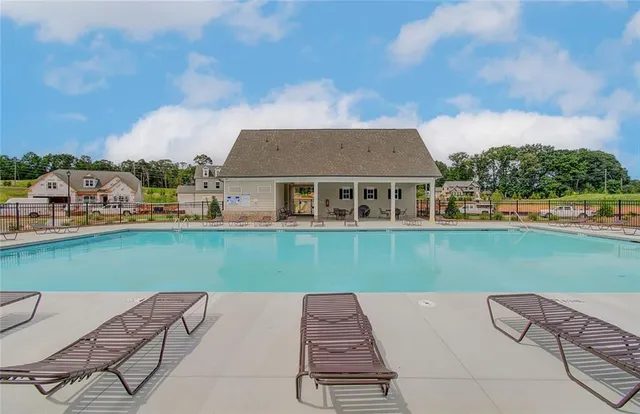 a front view of a house with swimming pool and porch