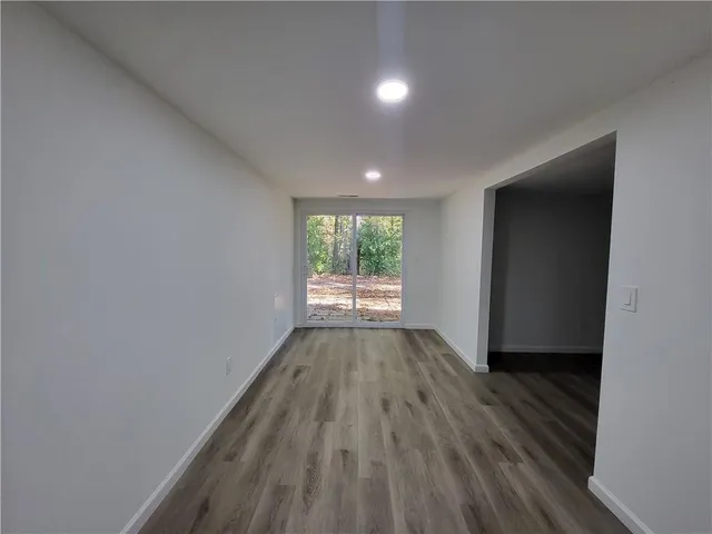 a view of a room with wooden floor and window