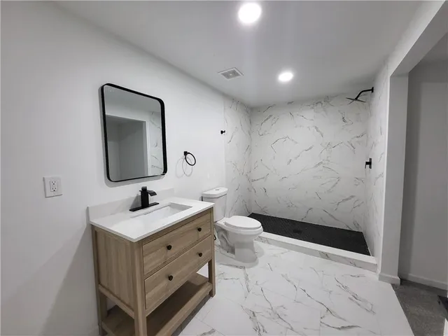 a bathroom with a sink a toilet and shower