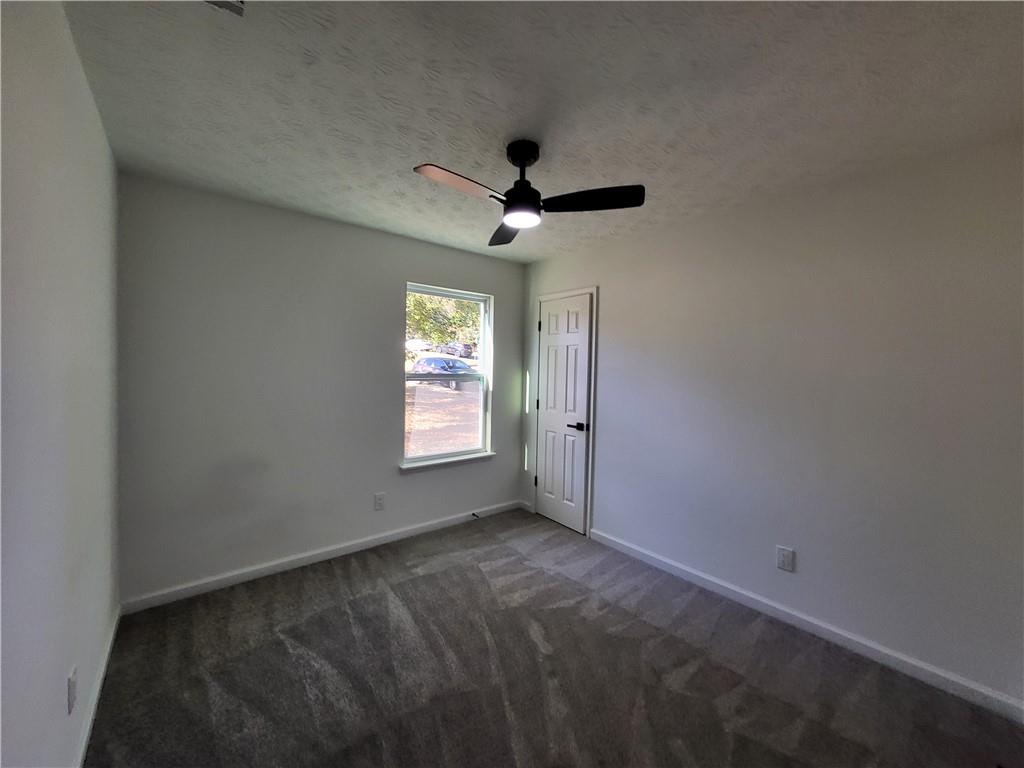 5729 Rock Road Union City, GA 30291 - Photo 10 of 17 an empty room with a window and a ceiling fan