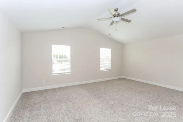 an empty room with a window and a ceiling fan