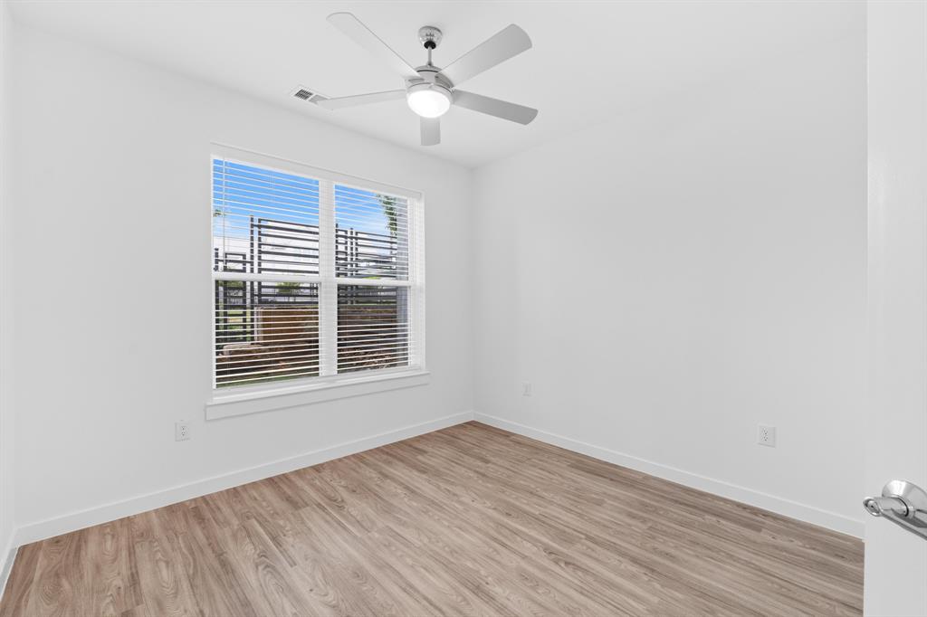 4801 Springdale Road, Unit 2010 Austin, TX 78723 - Photo 20 of 34 Bright room featuring wood-finish flooring, a contemporary ceiling fan with integrated lighting, and a window with horizontal blinds