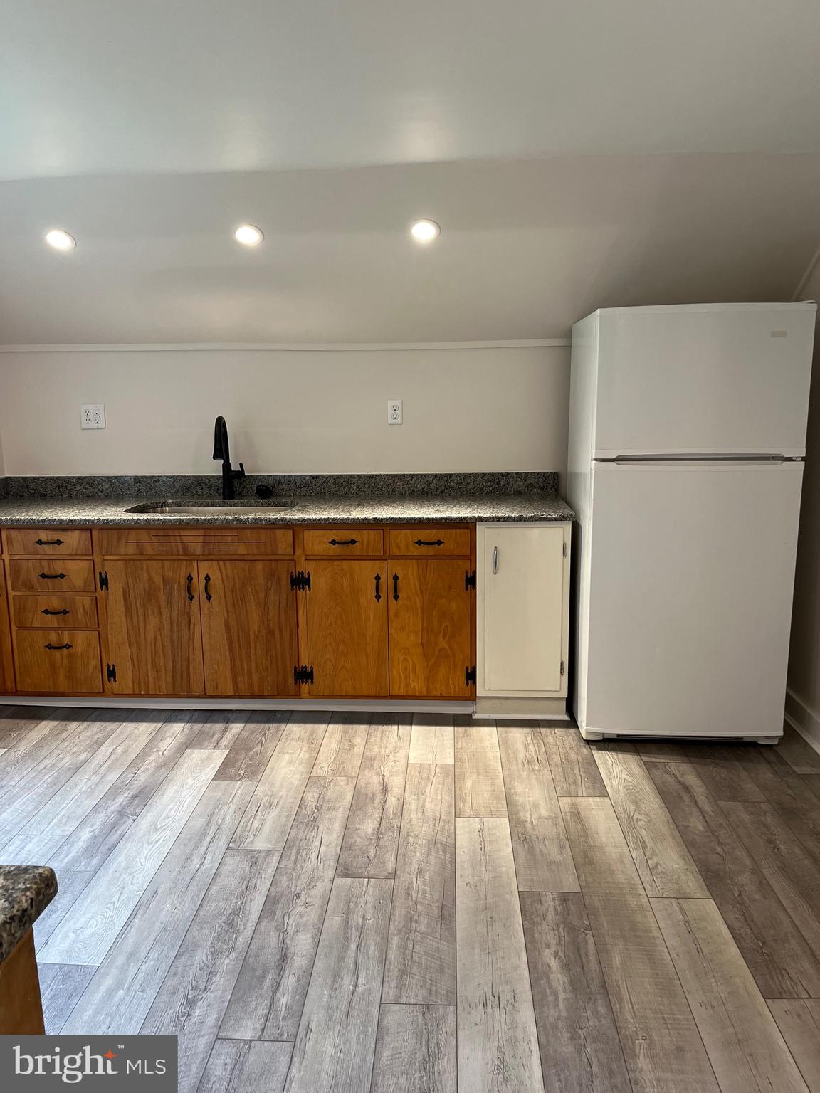 917 A A N Old Road, Unit 2 Strasburg, PA 17579 - Photo 2 of 7 a view of an empty room with wooden floor and a refrigerator