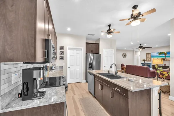 a kitchen with stainless steel appliances kitchen island granite countertop a sink and cabinets